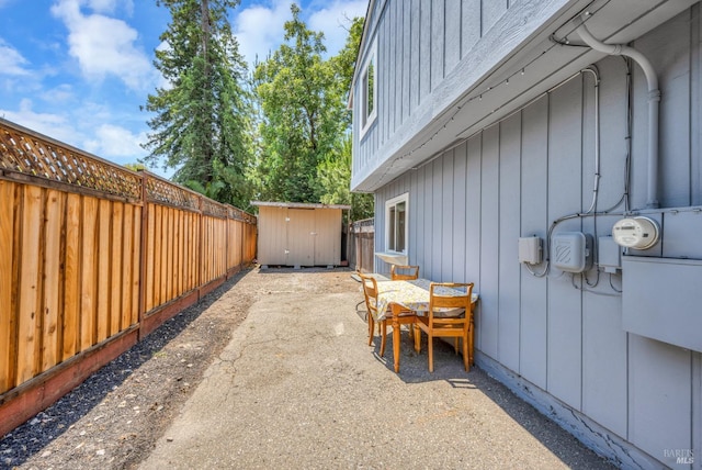 view of patio with a storage shed, an outbuilding, and a fenced backyard