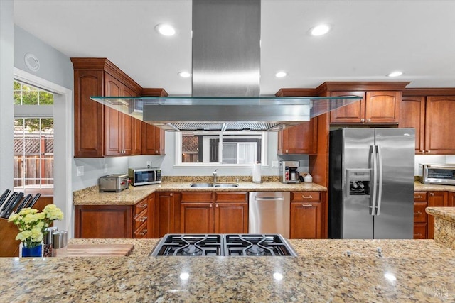 kitchen with a sink, light stone counters, a toaster, stainless steel appliances, and recessed lighting