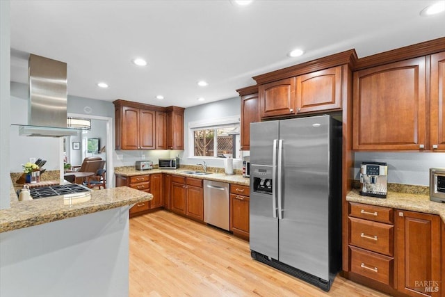 kitchen with appliances with stainless steel finishes, a sink, light wood finished floors, recessed lighting, and island exhaust hood