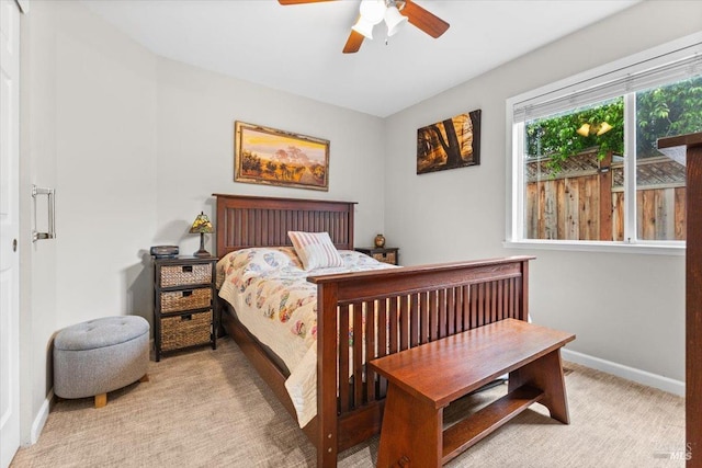 bedroom featuring light colored carpet, baseboards, and ceiling fan