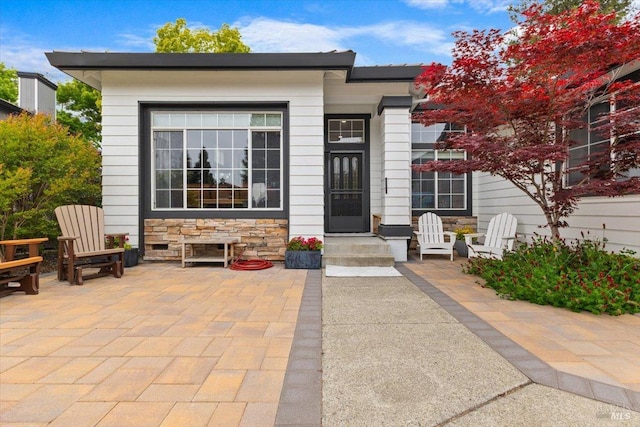view of front facade with a patio area and stone siding