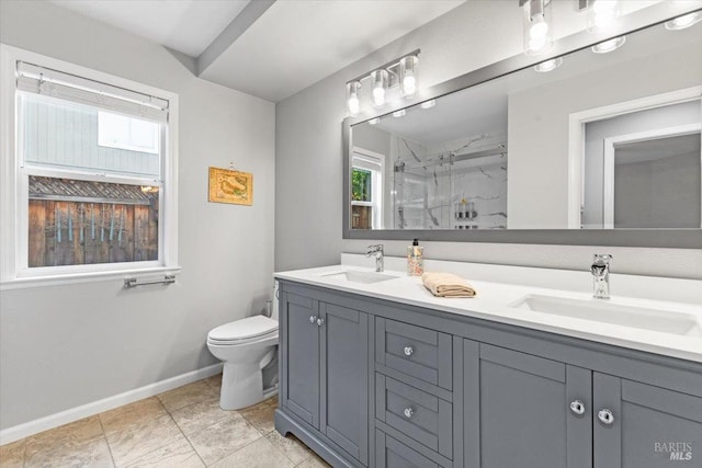 full bath featuring a sink, a marble finish shower, baseboards, and toilet