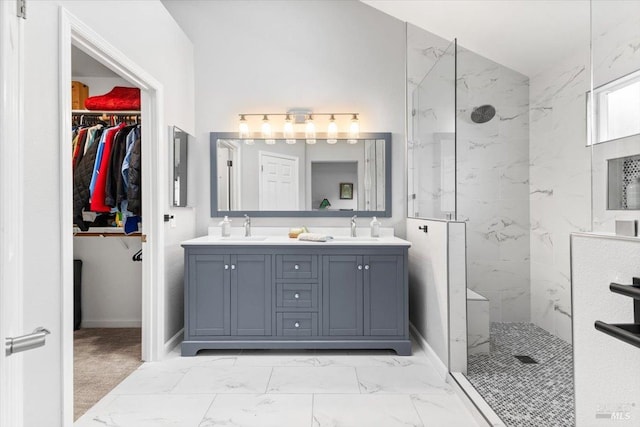 full bathroom with a sink, a marble finish shower, double vanity, and marble finish floor