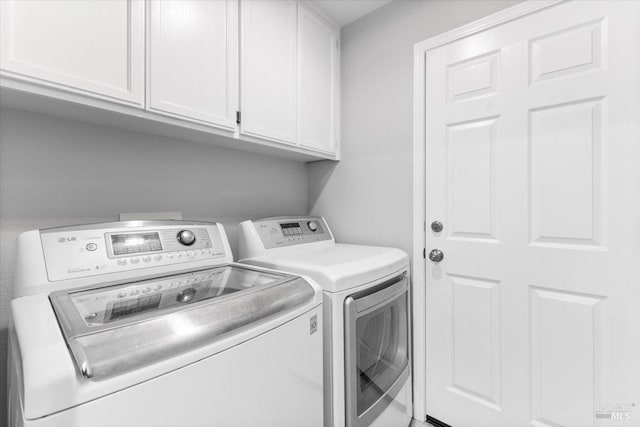 clothes washing area featuring cabinet space and washer and dryer