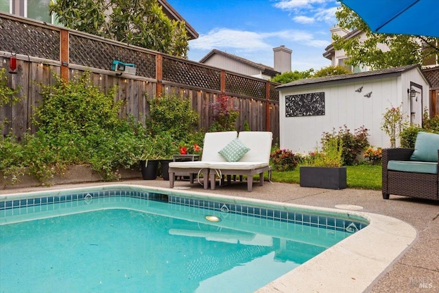 view of swimming pool featuring a fenced backyard, a patio area, and an outbuilding