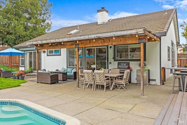 back of house featuring outdoor lounge area, a patio, a chimney, a tile roof, and outdoor dining space