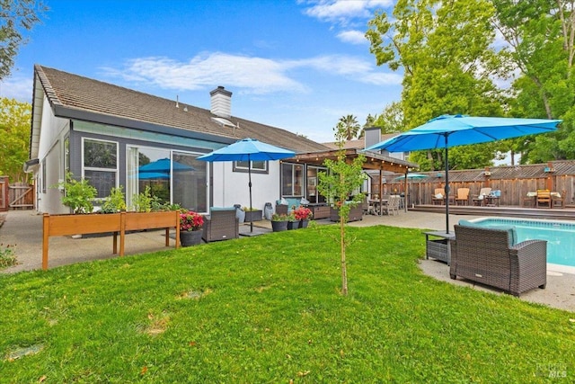 back of house featuring an outdoor living space, a lawn, fence, and a patio