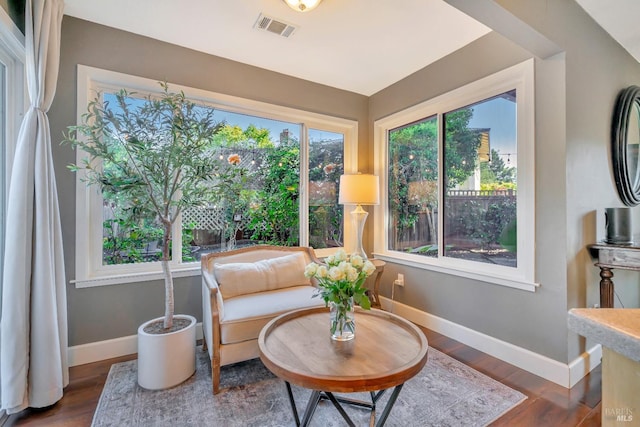 living area with visible vents, wood finished floors, and baseboards