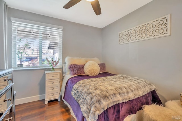 bedroom with ceiling fan, dark wood-style floors, and baseboards