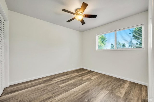 unfurnished room with baseboards and wood finished floors