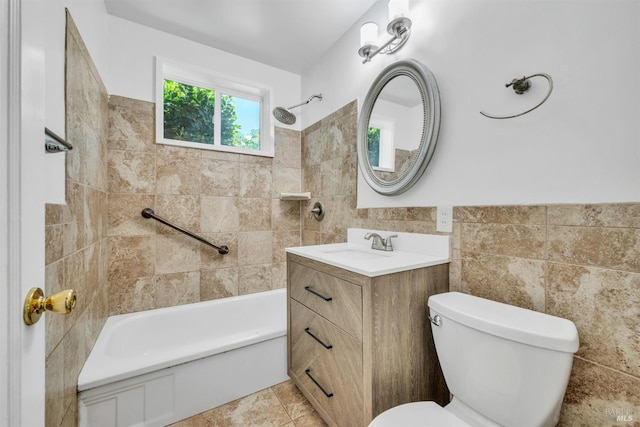 bathroom featuring wainscoting, washtub / shower combination, vanity, toilet, and tile walls