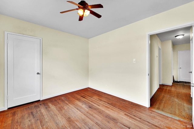 unfurnished room featuring wood finished floors, ceiling fan, and baseboards