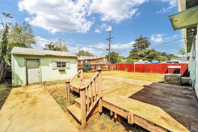view of yard with an outbuilding, a wooden deck, and a fenced backyard