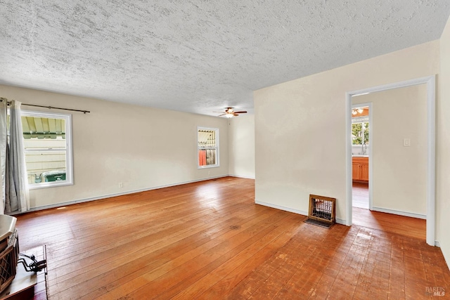 empty room with a textured ceiling, ceiling fan, and light wood-style flooring