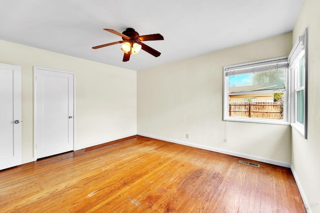 unfurnished bedroom with a ceiling fan, visible vents, baseboards, and light wood-type flooring