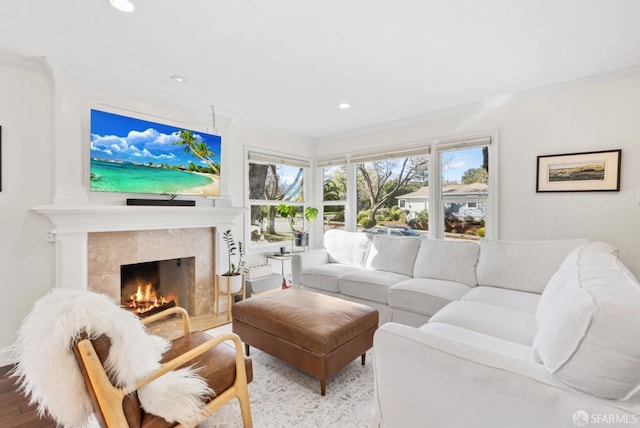 living room featuring recessed lighting, ornamental molding, and a tiled fireplace