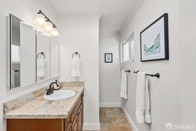 bathroom with vanity, ornamental molding, baseboards, and stone finish floor