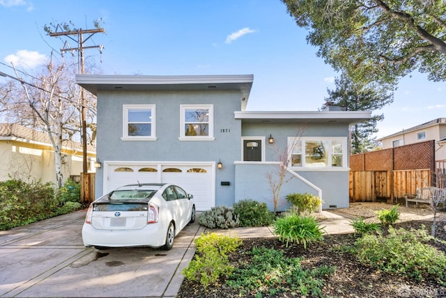 view of front facade featuring concrete driveway, a garage, fence, and stucco siding