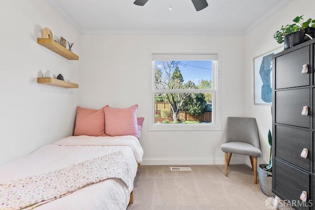 carpeted bedroom with baseboards, ornamental molding, ceiling fan, and visible vents
