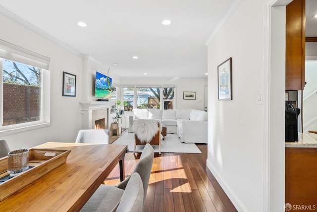dining area with recessed lighting, ornamental molding, dark wood-style floors, and a lit fireplace