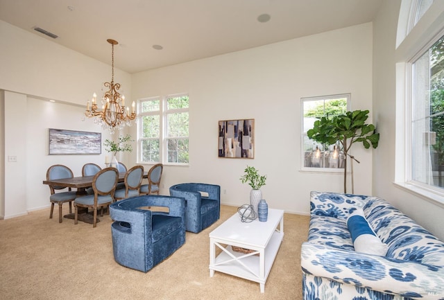 living room featuring carpet floors, visible vents, a notable chandelier, and a wealth of natural light