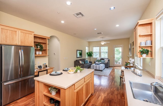 kitchen with visible vents, open shelves, arched walkways, and freestanding refrigerator