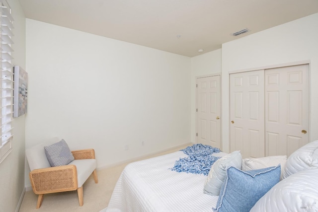bedroom featuring a closet, baseboards, carpet flooring, and visible vents
