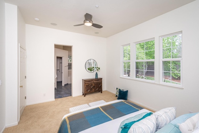 bedroom with baseboards, ceiling fan, and light carpet