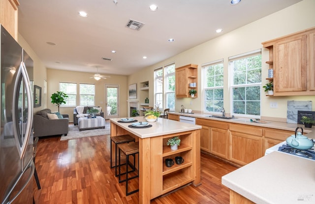 kitchen featuring visible vents, open shelves, light brown cabinets, and freestanding refrigerator