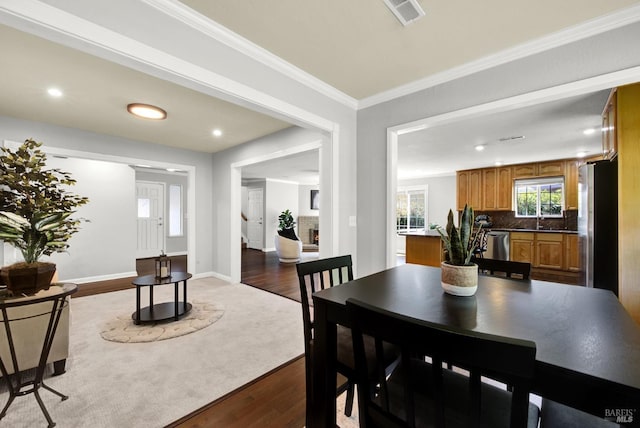 dining space with crown molding, recessed lighting, baseboards, visible vents, and dark wood-style floors