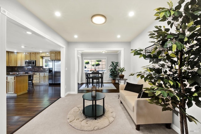 living room with recessed lighting, baseboards, dark wood finished floors, and dark colored carpet