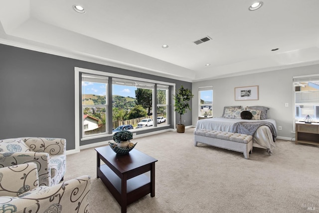 bedroom with recessed lighting, a raised ceiling, and light carpet