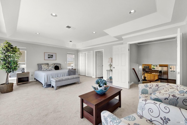 bedroom featuring stainless steel refrigerator with ice dispenser, visible vents, a raised ceiling, light carpet, and recessed lighting
