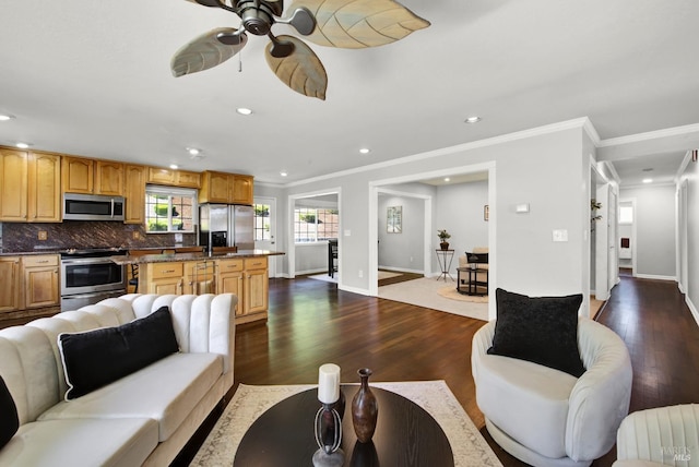 living area with ceiling fan, recessed lighting, baseboards, dark wood-type flooring, and ornamental molding