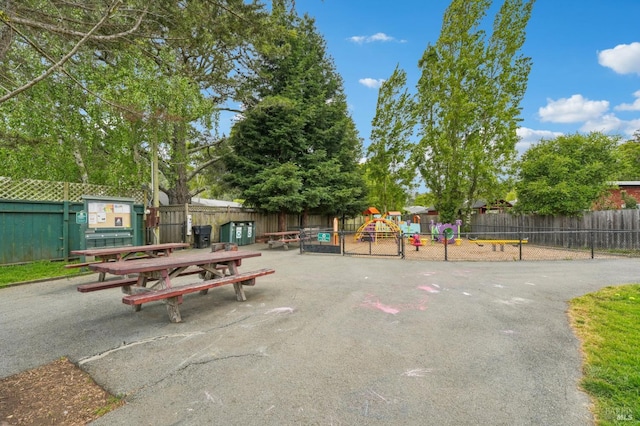 view of community featuring playground community and fence