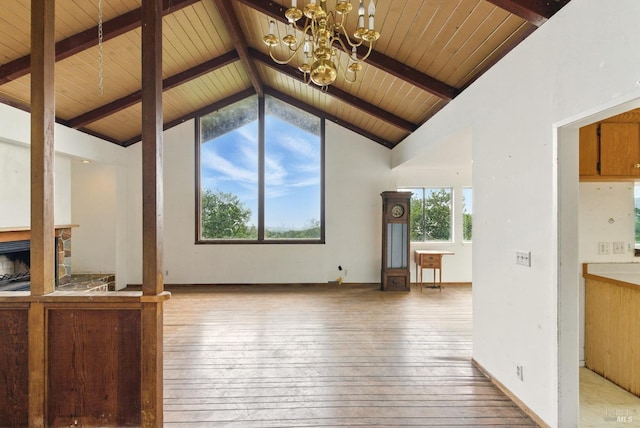 unfurnished living room with an inviting chandelier, wooden ceiling, light wood-style flooring, and beam ceiling