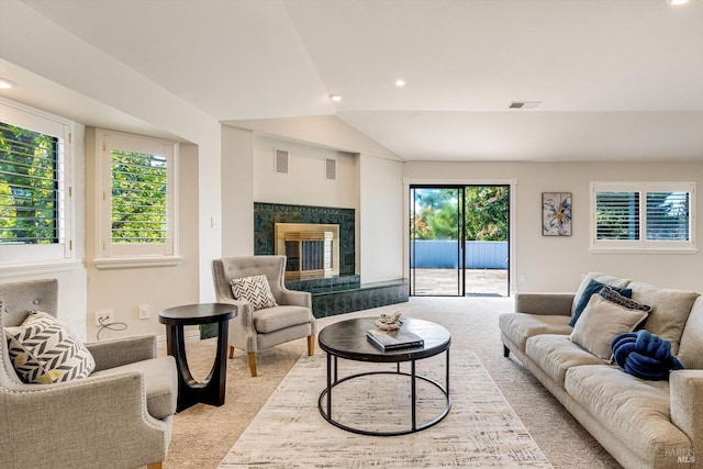 living area featuring visible vents, vaulted ceiling, light colored carpet, and a fireplace