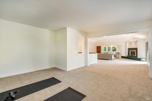 unfurnished living room featuring baseboards, a high end fireplace, and carpet flooring