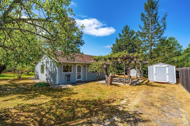 view of yard featuring fence, a shed, and an outbuilding