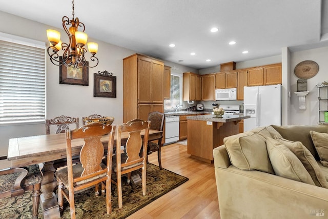 8724 Windsor Rd, Windsor, CA 95492 - kitchen featuring an inviting chandelier, white appliances, light wood-style floors, open floor plan, and a center island