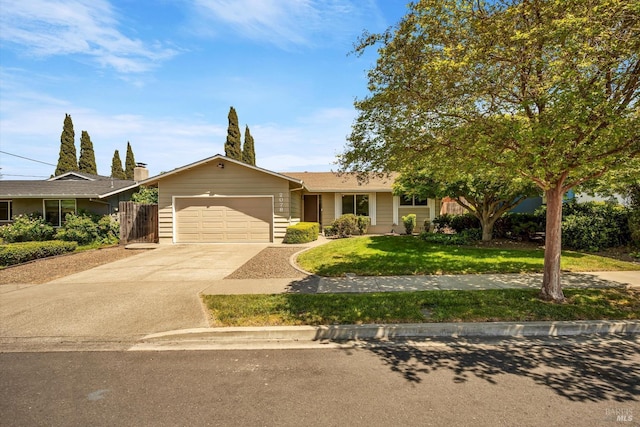 single story home featuring an attached garage, a front yard, and concrete driveway