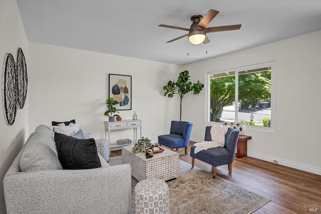 living room with baseboards, a ceiling fan, and wood finished floors