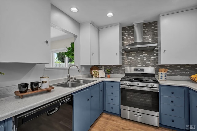kitchen featuring wall chimney range hood, black dishwasher, blue cabinets, and stainless steel gas stove