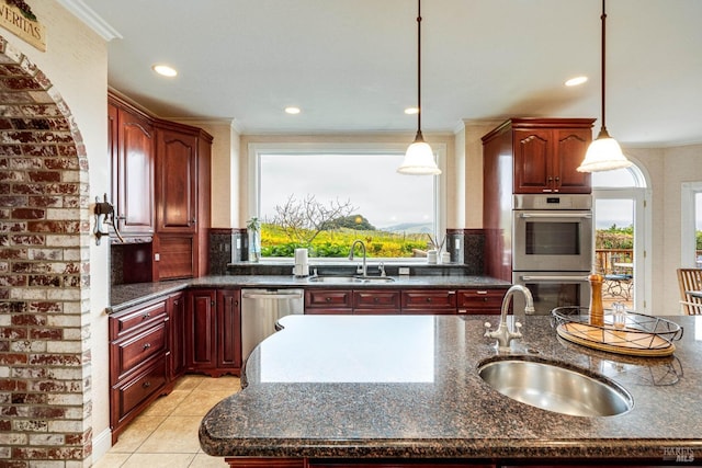 kitchen featuring reddish brown cabinets, a sink, stainless steel appliances, and decorative backsplash