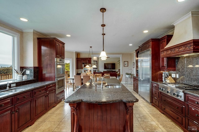 kitchen with appliances with stainless steel finishes, dark brown cabinets, and a sink