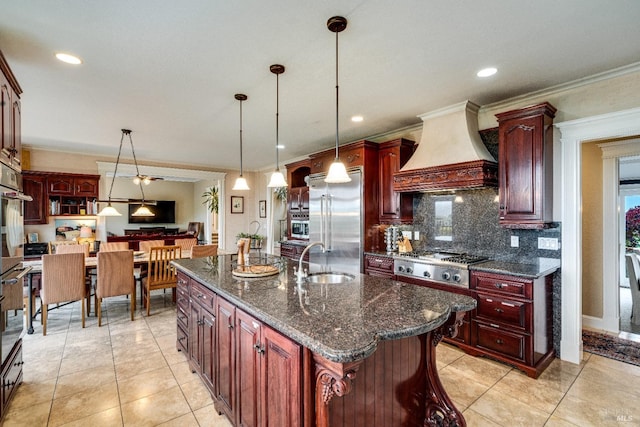 kitchen featuring a sink, stainless steel appliances, dark brown cabinets, ornamental molding, and custom exhaust hood