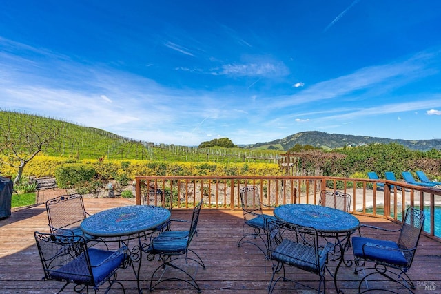 wooden deck featuring a mountain view and outdoor dining area