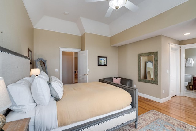bedroom featuring light wood finished floors, a ceiling fan, ensuite bath, and baseboards