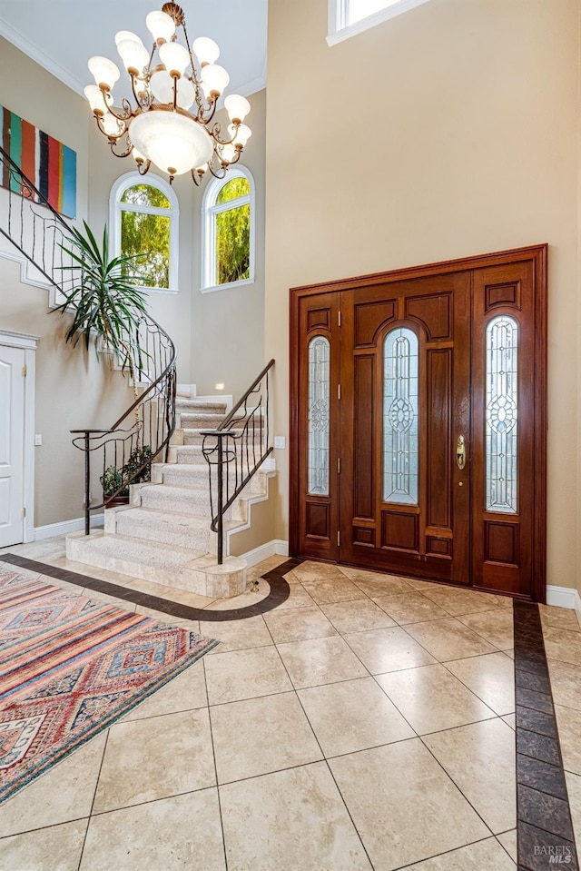 foyer with baseboards, crown molding, stairs, and a high ceiling
