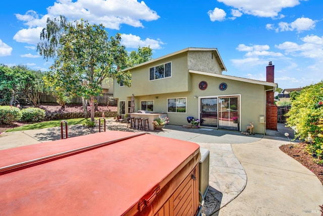 1163 Granada St, Vallejo, CA 94591 - back of property featuring a patio area, a hot tub, stucco siding, and a chimney